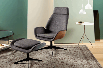 A chair and ottoman in a room with a rug.