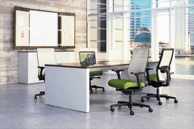 A conference room with green chairs and white tables.